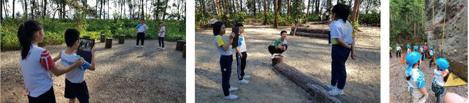 Children in school uniforms doing outdoor activities near logs and a climbing wall in a wooded area.